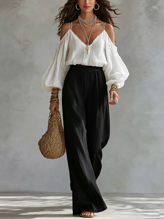 Conjunto compuesto por una camiseta sin mangas blanca con hombros al aire y unos pantalones negros de pierna ancha